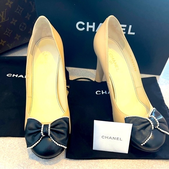 CHANEL Shoes - Chanel beige and black pumps with pearl embellished bow. Classic and stunning!
